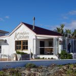 pexels photo 30679754 30679754 A bright and inviting beachside restaurant with charming outdoor seating and lush greenery.